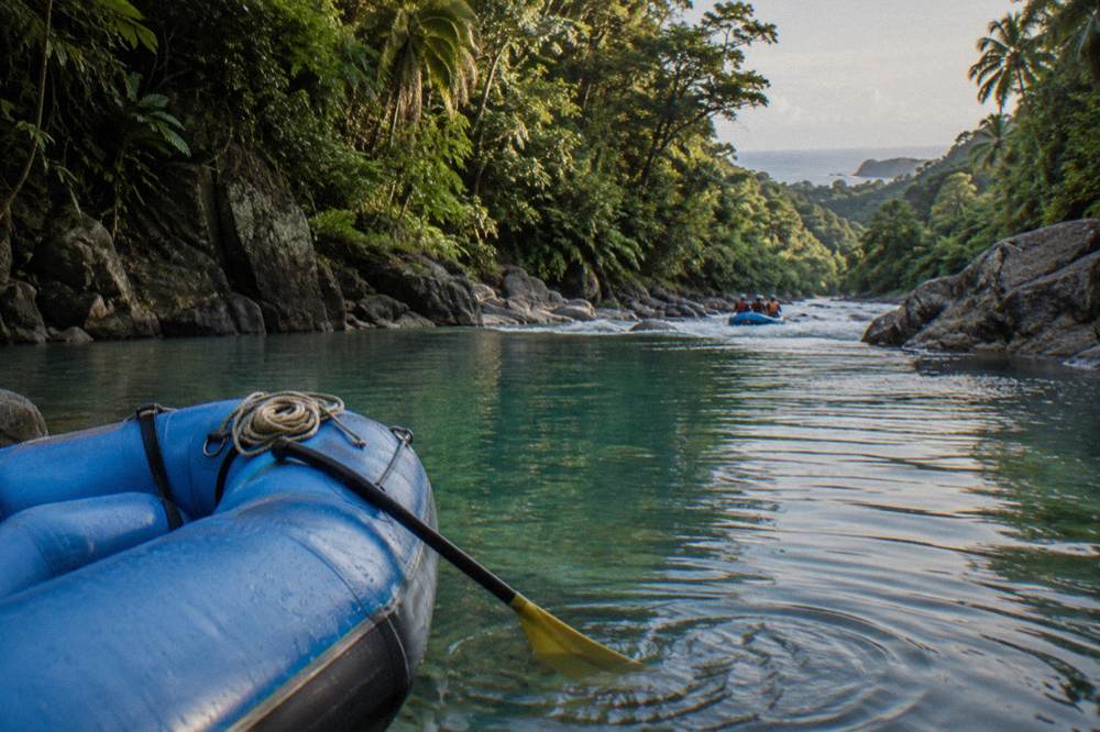 A calm turquoise pool between jungle banks where a raft waits before the next rapid