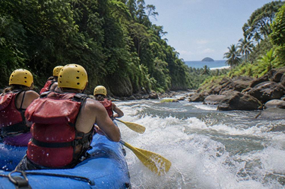 Spray flying off the bow of a raft as it drops into a wave train