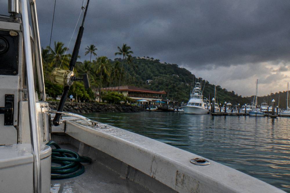 Dark afternoon storm clouds gathering over Pacific ocean horizon from a boat deck