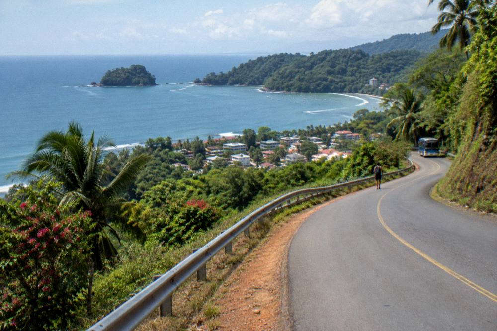 Coastal highway curving along green hills above the ocean