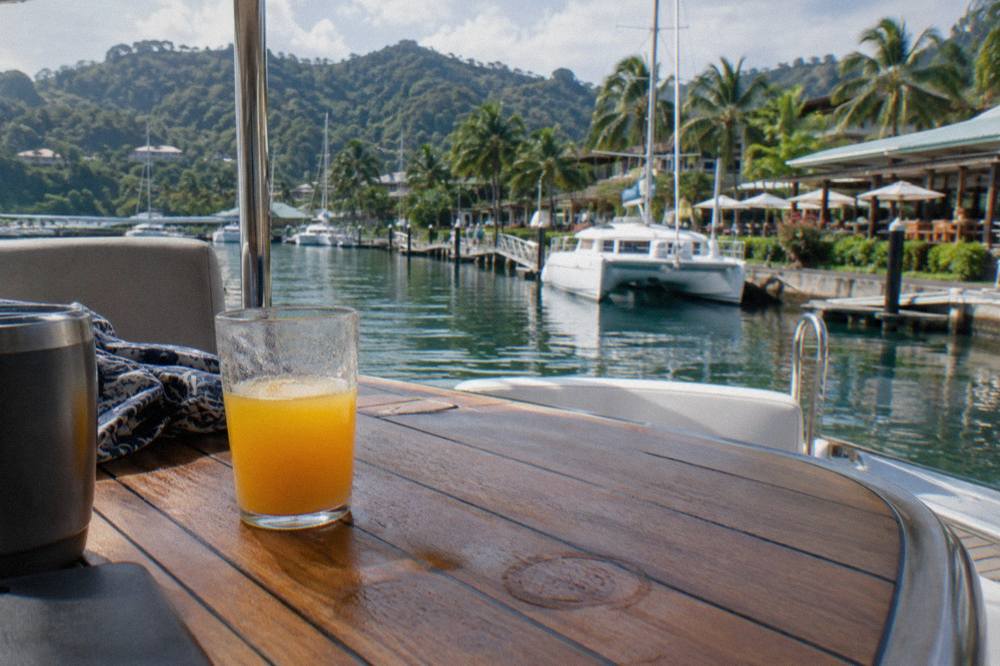 A serving of fresh fruit and drinks laid out on a catamaran deck table