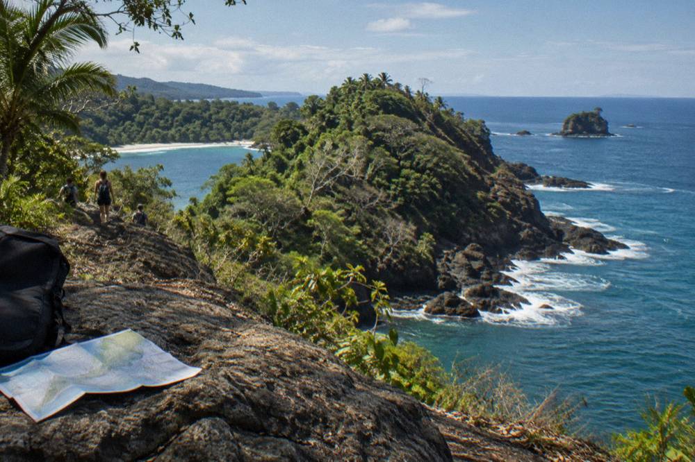 Rocky headland jutting into the Pacific Ocean with dense forest and blue water