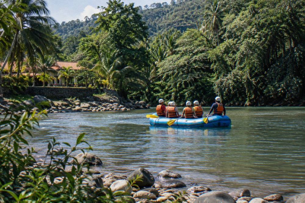 Paddlers in helmets and life vests on calm stretch between rapids