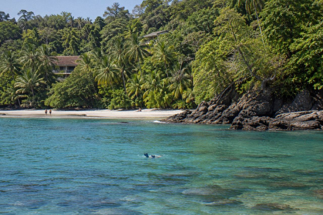 Calm turquoise water over a rocky reef near the Manuel Antonio coastline