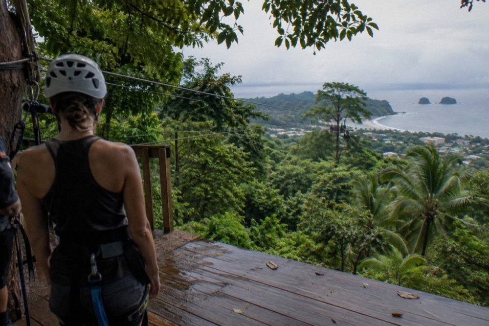 Zipline platform high in a rainforest canopy with cables stretching to a distant tree