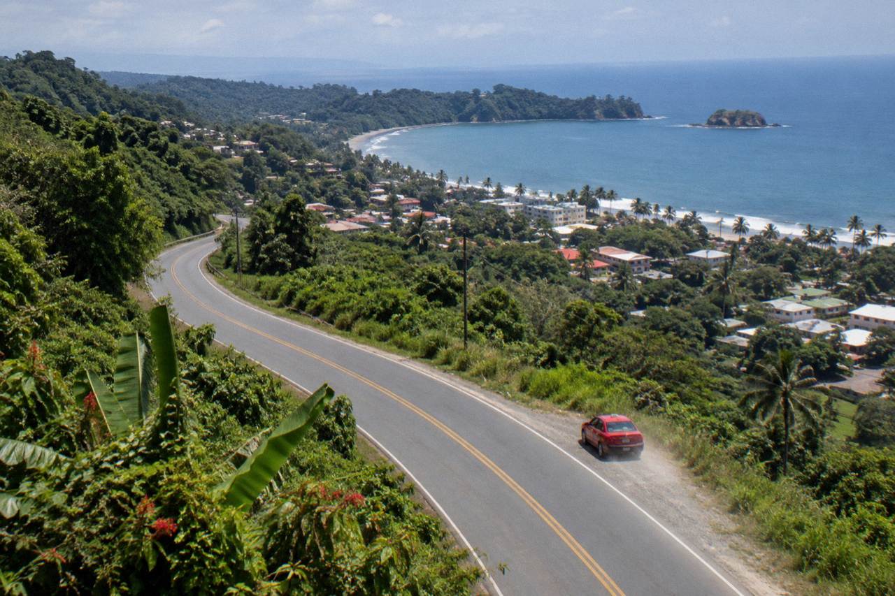 Coastal highway winding along green hills above the Pacific ocean near Quepos